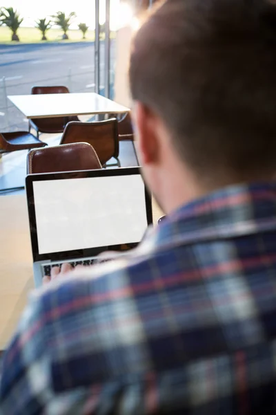 Vista trasera del hombre usando su computadora portátil —  Fotos de Stock