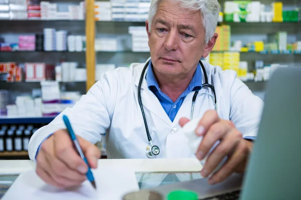 Farmacêutico que escreve prescrições para medicamentos — Fotografia de Stock