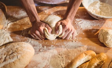 Hands of baker kneading a dough clipart