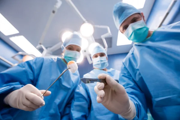 Cirurgiões segurando ferramentas cirúrgicas e algodão — Fotografia de Stock