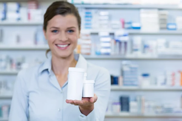 Farmacêutico mostrando recipientes de medicamento — Fotografia de Stock