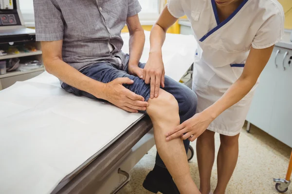 Médica examinando pacientes joelho — Fotografia de Stock