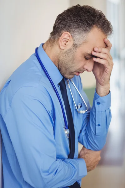 Sad doctor leaning against the wall — Stock Photo, Image