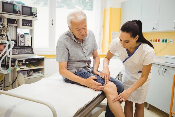 Female doctor examining patients knee — Stock Photo, Image