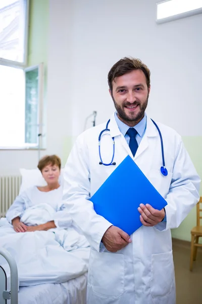 Médico sorridente segurando um relatório médico — Fotografia de Stock