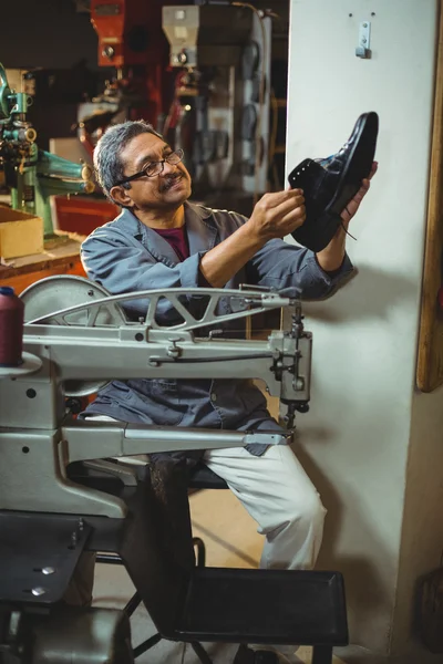 Shoemaker examining a shoe — Stock Photo, Image