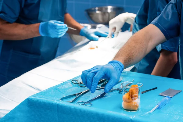 Cirurgião que toma uma tesoura da bandeja — Fotografia de Stock