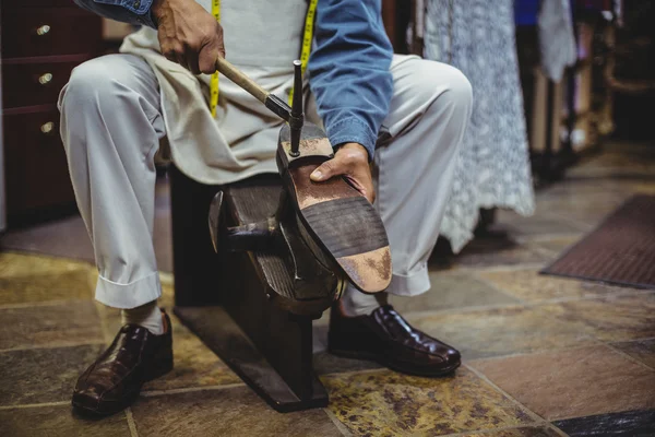 Schoenmaker hameren op een schoen — Stockfoto