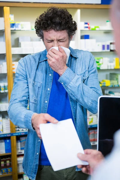 Kunde gibt Rezept an Apotheker ab — Stockfoto