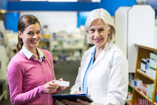 Farmacista scrittura prescrizioni per il cliente — Foto Stock