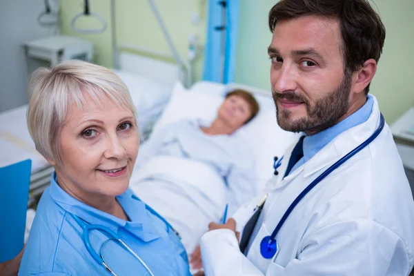 Врач и медсестра в палате больницы — стоковое фото