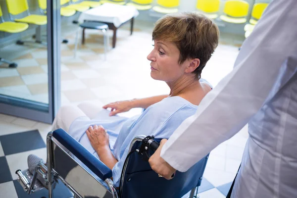 Médecin poussant le patient âgé en fauteuil roulant — Photo