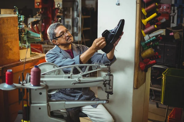 Shoemaker examining a shoe — Stock Photo, Image