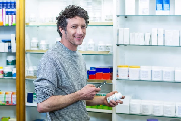 Cliente che utilizza il telefono con bottiglia di farmaco — Foto Stock