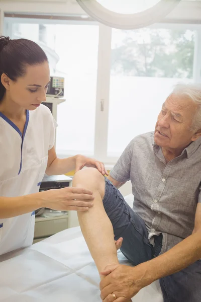 Médica examinando pacientes joelho — Fotografia de Stock