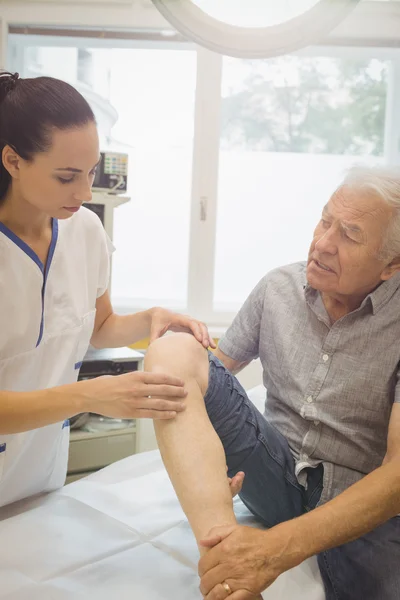 Médecin féminin examinant les patients genou — Photo