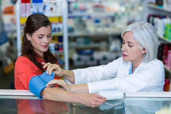 Farmacéutico control de la presión arterial del cliente —  Fotos de Stock