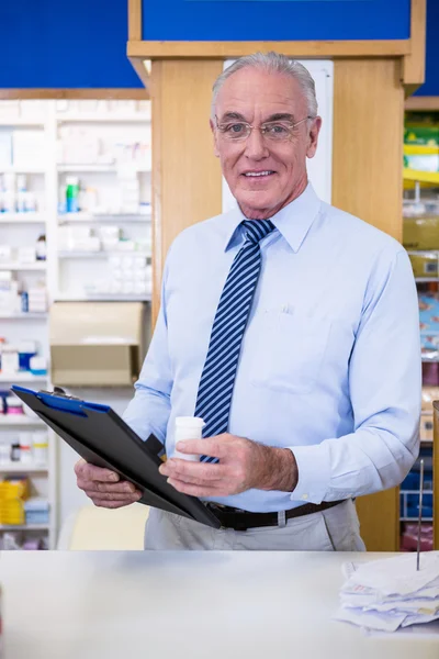 Farmaceuta, trzymając pojemnik medycyny i schowka — Zdjęcie stockowe