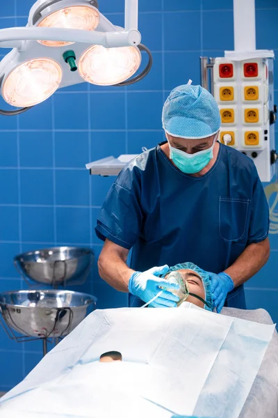 Chirurgien plaçant un masque à oxygène sur le visage du patient — Photo