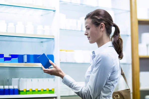 Kunde checkt eine Schachtel mit Medikamenten — Stockfoto