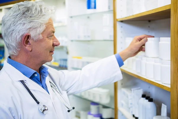 Farmacêutico verificando medicamentos na farmácia — Fotografia de Stock