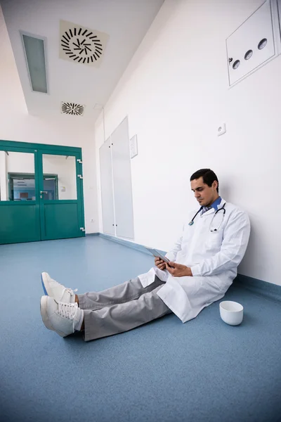 Dokter zittend op de vloer en het gebruik van Tablet PC — Stockfoto