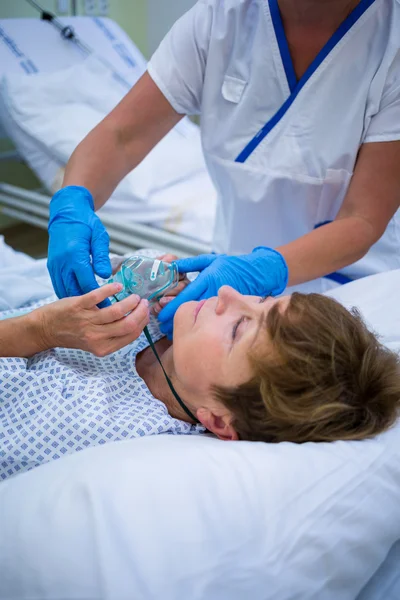 Enfermera colocando una máscara de oxígeno en la cara del paciente —  Fotos de Stock