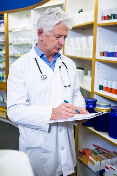 Farmacêutico escrevendo na área de transferência — Fotografia de Stock