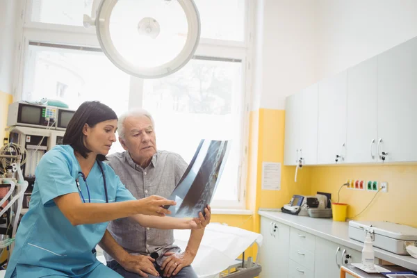 Läkaren diskuterar röntgen med patienten — Stockfoto