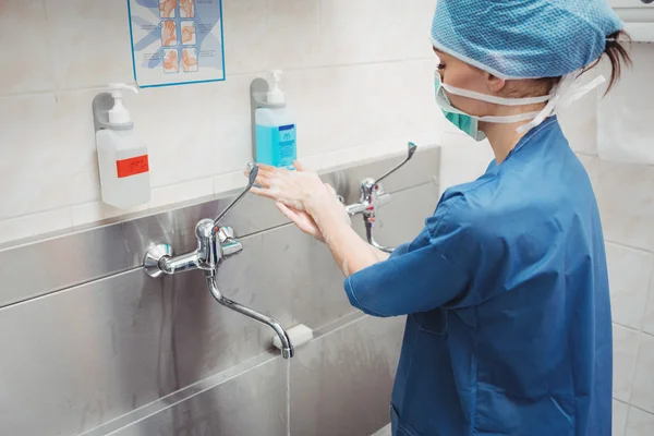 Vrouwelijke chirurg haar handen wassen — Stockfoto