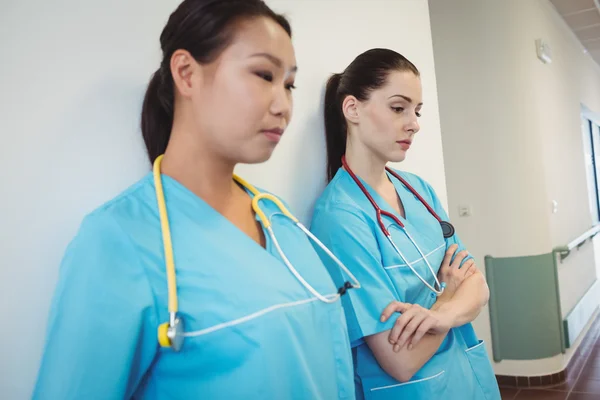 Triest verpleegkundige leunend tegen de muur — Stockfoto