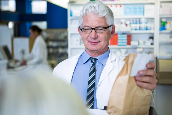 Pharmacist holding a medicine package — Stock Photo, Image