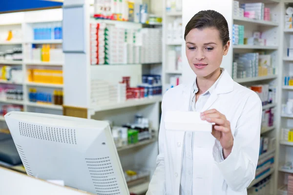 Farmacêutico fazendo registro de prescrição através de computador — Fotografia de Stock