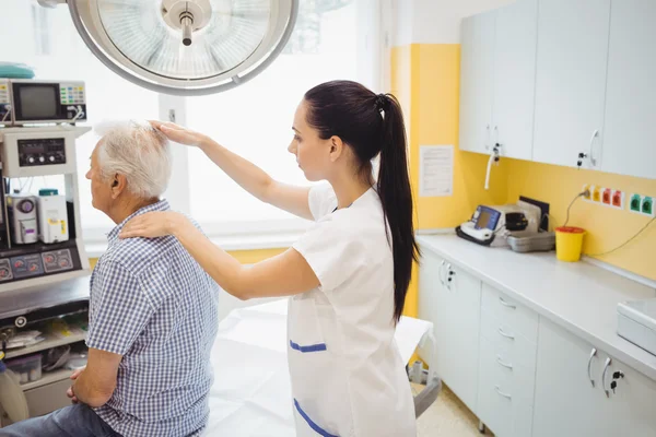 Médica examinando um paciente — Fotografia de Stock