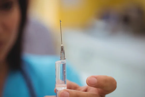 Médica mulher segurando uma injeção — Fotografia de Stock