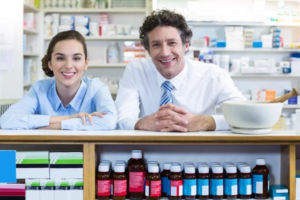 Farmacêuticos apoiados no balcão na farmácia — Fotografia de Stock