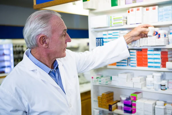 Farmacista che controlla una bottiglia di farmaco — Foto Stock