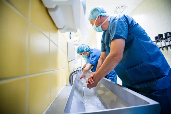 Surgeons washing hands at washbasin — Stock Photo, Image