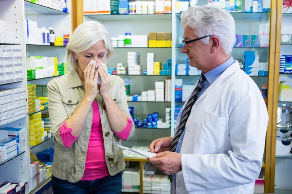 Kunde niest, während er Apotheker Rezept gibt — Stockfoto