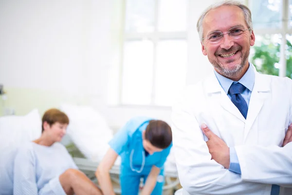 Lachende arts permanent met armen gekruist — Stockfoto