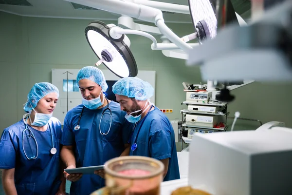 Хирурги обсуждают за планшетом — стоковое фото