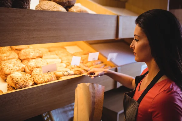 Kvinnliga baker packning söt mat — Stockfoto