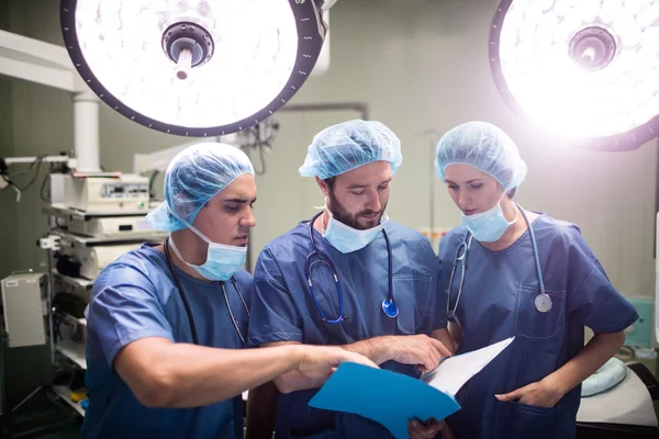 Хирурги обсуждают записи пациентов — стоковое фото