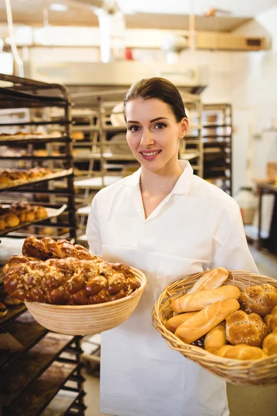 Bäckerin hält Korb mit süßen Lebensmitteln — Stockfoto