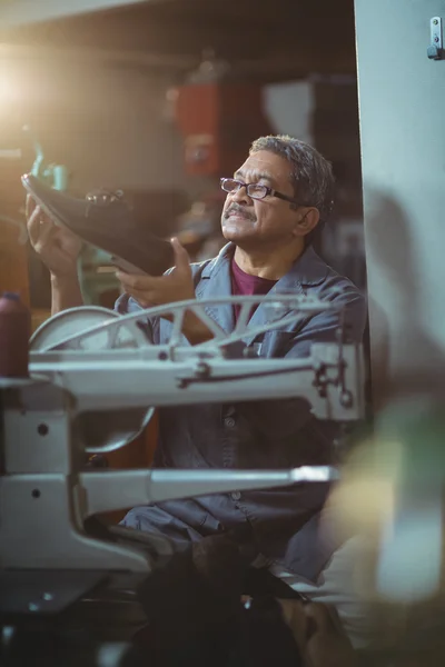 Shoemaker examining a shoe — Stock Photo, Image