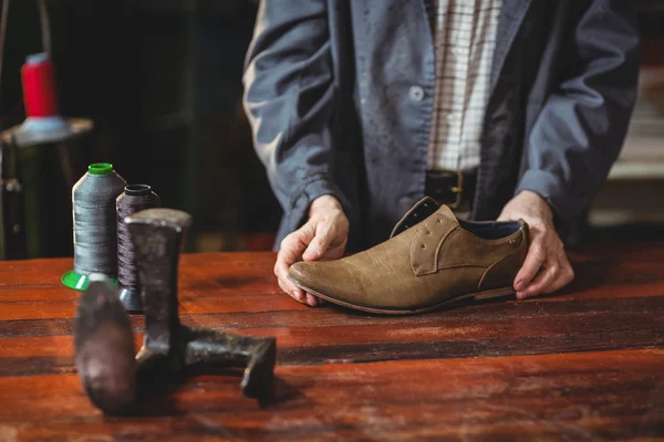 Calzolaio esaminando una scarpa — Foto Stock