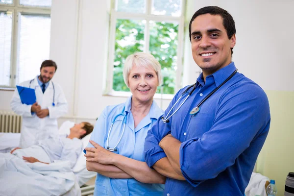 Médico y enfermera con los brazos cruzados — Foto de Stock