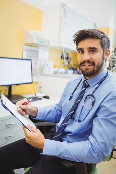 Doctor writing on a clipboard — Stock Photo, Image