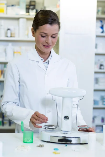 Pharmacist measuring tablets with pharmacy scale — Stock Photo, Image