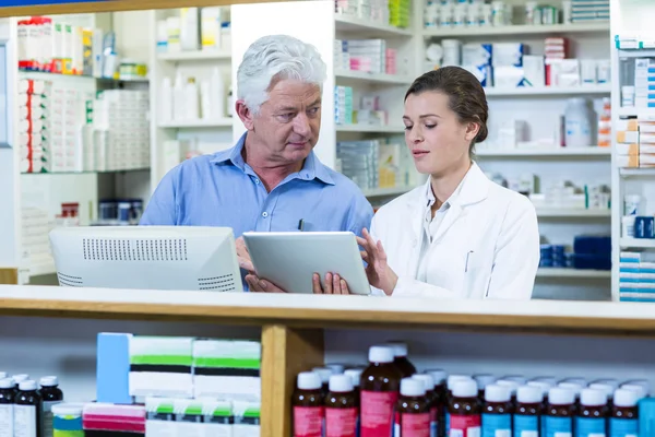 Farmacêuticos que usam comprimido no balcão — Fotografia de Stock